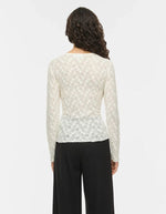 Silhouette de dos avec le Top ajusté à manches longues pour femme, modèle Fay de la marque Vila. Tissu en mesh extensible coloris Regret (nuance foncée) avec des détails raffinés en dentelle et un col rond classique