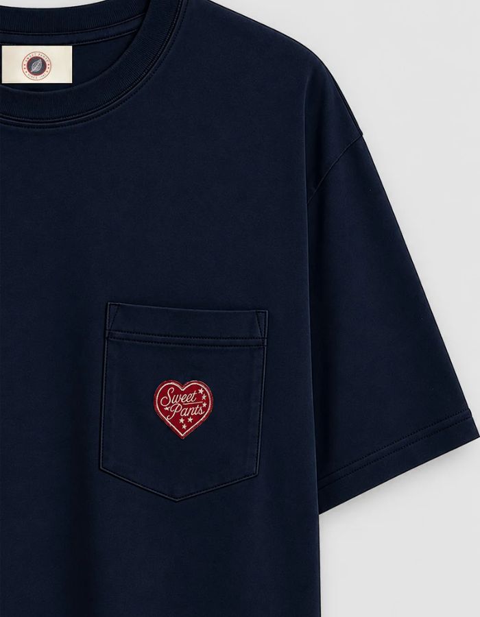 Poche du T-shirt confort unisexe en coton lourd bleu nuit noir avec col rond et patch cœur en feutrine sur la poitrine, modèle Heritage Tee couleur Night de la marque Sweet Pants.