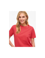 Femme souriante portant un t-shirt rouge corail en jersey de coton biologique à manches courtes et col rond.
