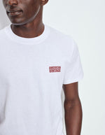 Haut du T-shirt à manches courtes pour homme de couleur blanc, modèle Ykobow de la marque American Vintage. Présente une coupe droite décontractée en coton doux avec un col rond et le logo American Vintage imprimé dans un style rétro sur la poitrine.