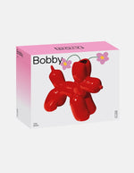 Boîte du Vase en céramique rouge vif Bobby par la marque DOIY. Silhouette sculpturale aux lignes géométriques et découpes graphiques modernes, mesurant 25 cm de longueur.