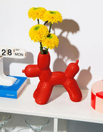 Fleurs jaune dans le Vase en céramique rouge vif Bobby par la marque DOIY. Silhouette sculpturale aux lignes géométriques et découpes graphiques modernes, mesurant 25 cm de longueur.