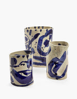 Trio des vases en grès artisanal Sophia par Marie Michielssen, de couleur blanche avec des motifs calligraphiques peints à la main en bleu profond. Silhouette organique asymétrique et design minimaliste de 19 cm de hauteur.