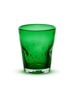 Verre à eau artisanal Memento Dune couleur vert émeraude, en verre soufflé à la bouche avec relief ergonomique ondulé et reflets précieux.