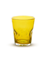 Verre à eau artisanal Memento Dune couleur jaune vif, en verre soufflé à la bouche avec forme ergonomique ondulée et reflets ensoleillés.