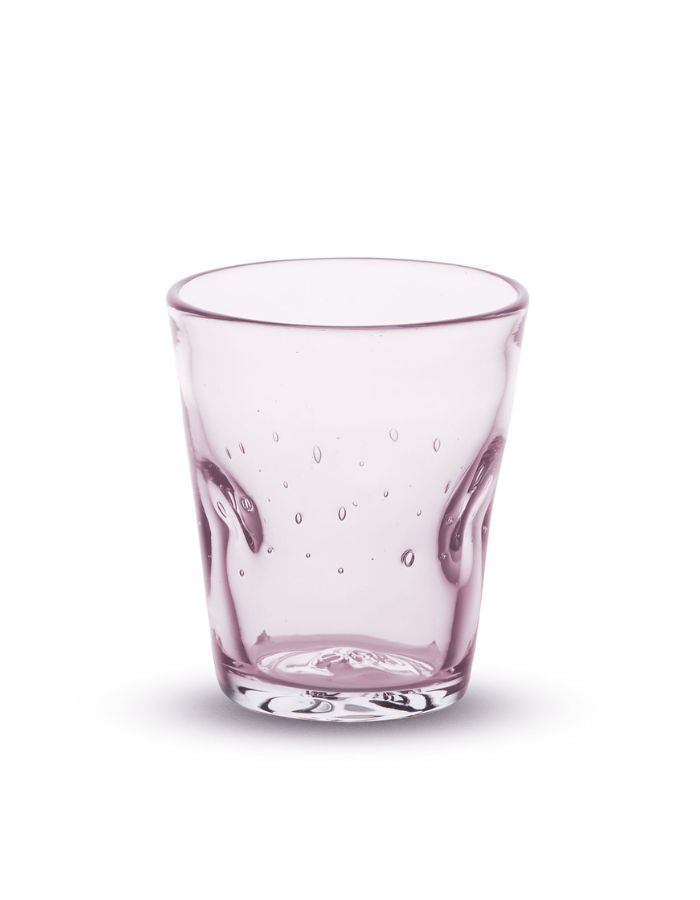 Vue de face du verre à eau artisanal Memento Dune couleur rose translucide, en verre soufflé à la bouche avec relief ondulé ergonomique et reflets poudrés.