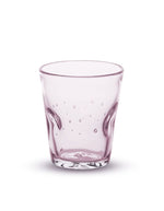 Vue de face du verre à eau artisanal Memento Dune couleur rose translucide, en verre soufflé à la bouche avec relief ondulé ergonomique et reflets poudrés.