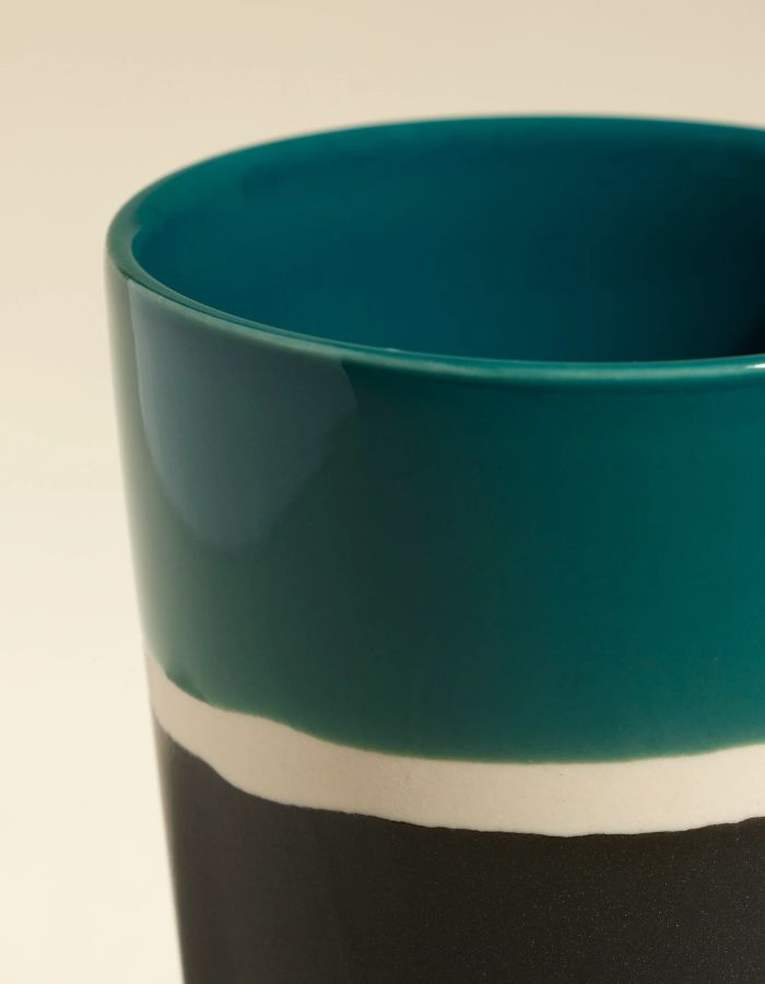 Détail du Verre en grès artisanal Sicilia par Maison Sarah Lavoine. Intérieur émaillé Bleu Sarah brillant et extérieur noir mat (Radis Noir). Fabriqué à la main en France par l'atelier Jars, hauteur 7,5 cm.