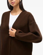 Manche de la Veste légère et ample pour femme de couleur marron foncé Coffee Bean, modèle Juice de la marque Vila. Présente un col en V, des manches longues à emmanchures tombantes et une fermeture discrète par boutons-pression.