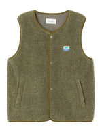 Veste sans manches pour homme de couleur vert kaki Varan Chiné, modèle Hoktown de la marque American Vintage. Confectionnée dans une matière épaisse effet mouton retourné shearling, elle présente un col montant bas, une fermeture à boutons-pression, deux poches zippées et un patch logo sur la poitrine.