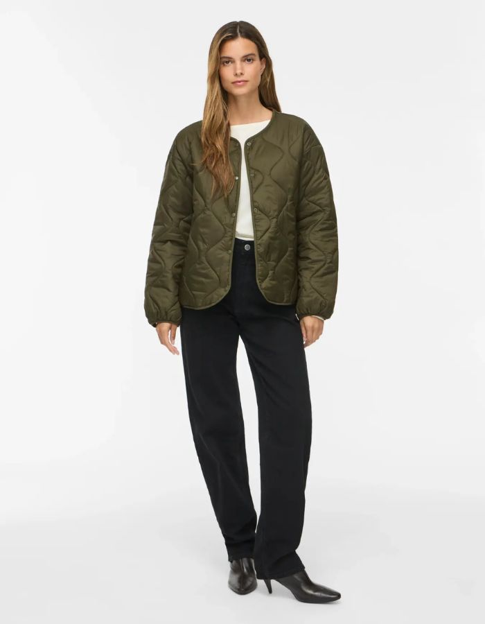 Silhouette de face avec la Veste matelassée légère et courte pour femme de couleur verte, modèle Dune de la marque Vila. Présente un col en V, des manches longues, des poches plaquées à l'avant et une fermeture par boutons-pression.