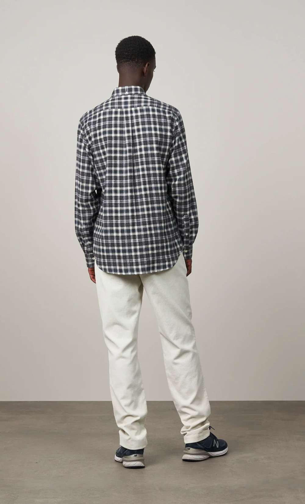 Homme de dos portant une chemise Pitt à carreaux carbone en flanelle de coton et un pantalon clair.