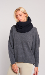 Femme portant un snood noir Maevy en alpaga, doux et élégant, sur un pull gris.