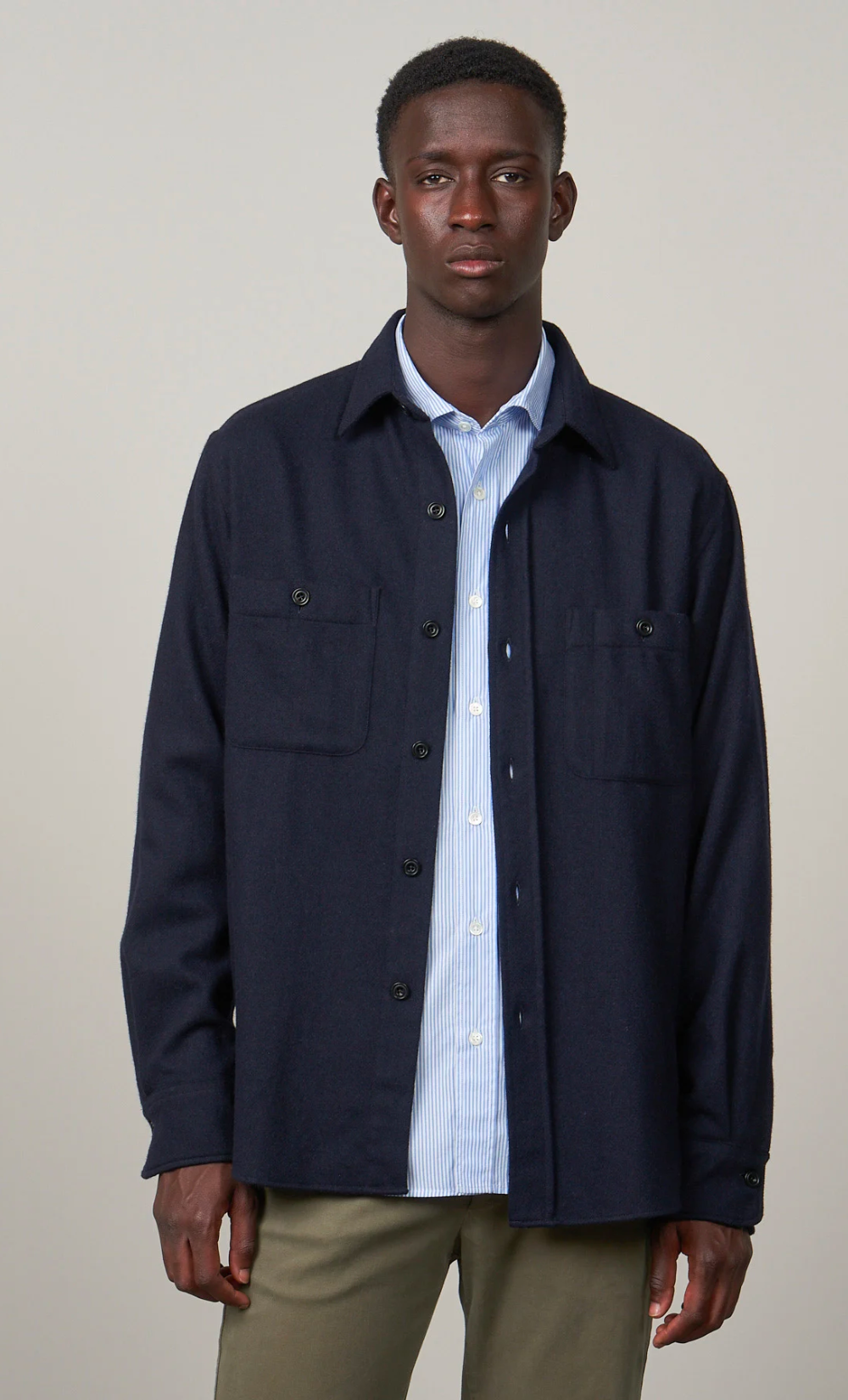 Homme portant une surchemise Percey bleu marine en laine recyclée, coupe regular, avec deux poches poitrines.