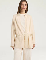 Vue de face du Cardigan à col rond pour femme en pure laine crème, modèle Klak Bis de la marque MOMONI. Présente des manches raglan amples, une fermeture à ruban de laine à nouer et des liserés en lurex doré.