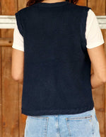 Dos du Gilet sans manches pour femme en maille bleu marine à col V et boutons en corne, modèle Melba de La Petite Étoile. Présente des finitions torsadées au col, aux emmanchures et au bas.
