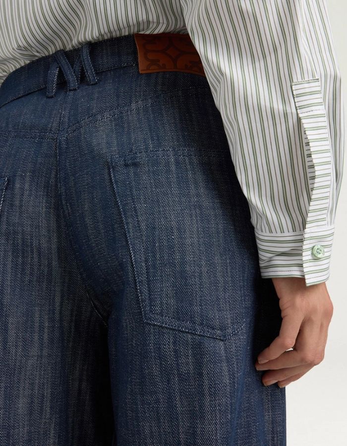 Bassin du Pantalon 5 poches en jean droit bleu pour femme, modèle Aoki de la marque MOMONI. Présente une fermeture par bouton clou, un passepoil en M au dos et une étiquette en cuir.