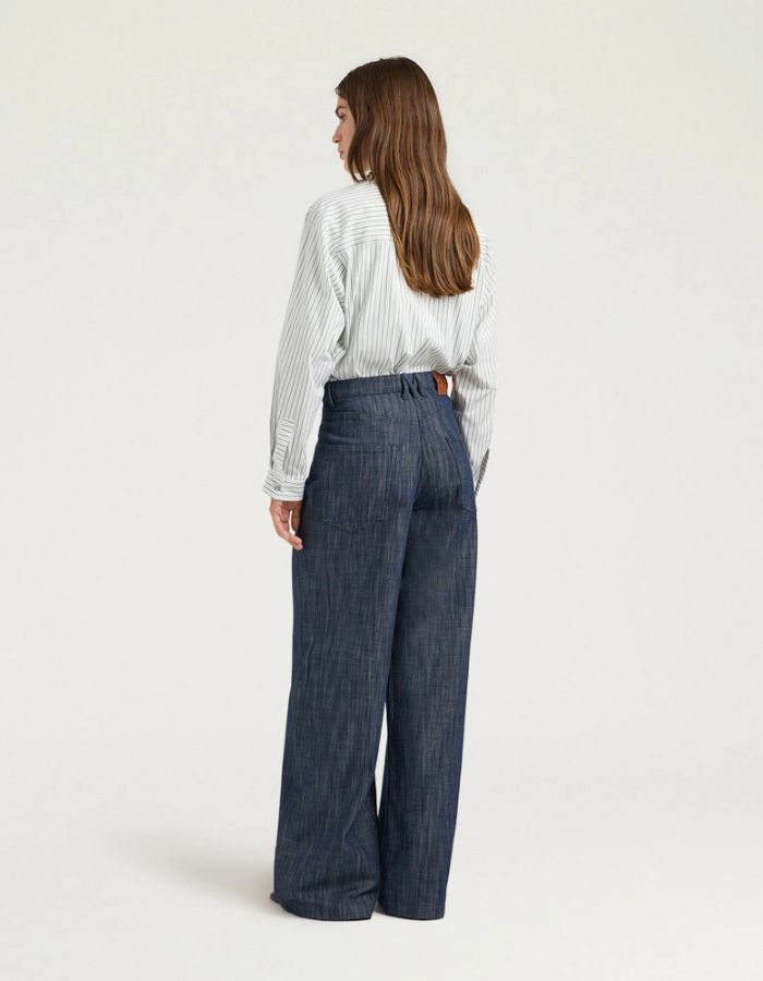 Dos du Pantalon 5 poches en jean droit bleu pour femme, modèle Aoki de la marque MOMONI. Présente une fermeture par bouton clou, un passepoil en M au dos et une étiquette en cuir.