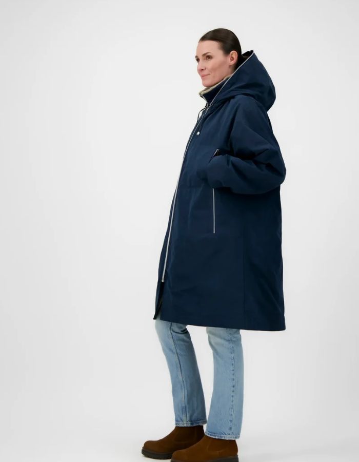Profil de la Parka longue déperlante bleu encre pour femme avec capuche et gilet intérieur amovible en fausse fourrure, modèle Elise Cor de la marque Prêt Pour Partir.