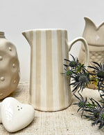 Ambiance déco avec le Grand pichet en céramique à rayures couleur sable, marque Opjet. Design vintage avec anse et bec verseur, d'une hauteur de 21,3 cm et d'une contenance de 1 litre.
