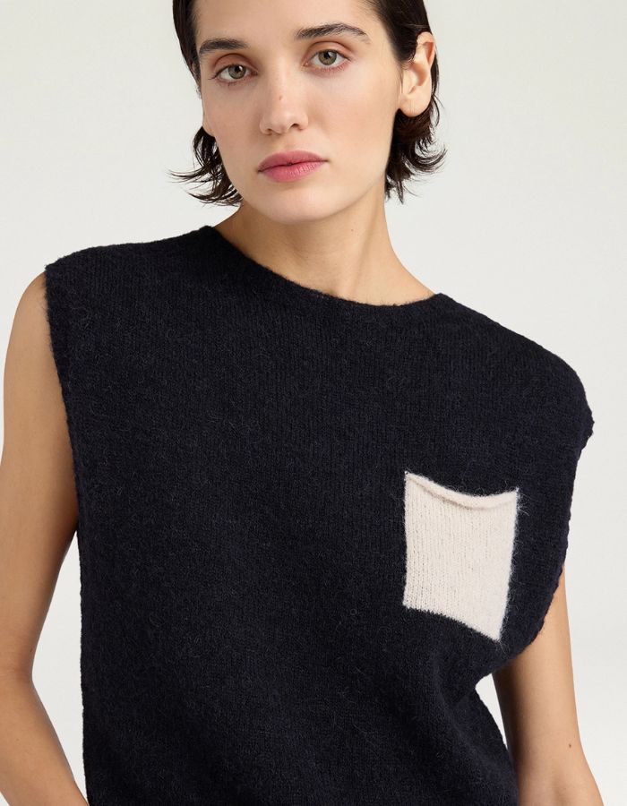 Col du Pull court pour femme en maille alpaga noire effet sweat, modèle Ansa de la marque MOMONI. Présente une coupe carrée avec une poche poitrine contrastée.