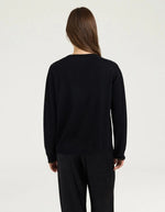 Dos du Pull pour femme en pure laine noire, modèle Astrid de la marque MOMONI. Présente une maille teinté en pièce et de délicates bordures en lurex doré aux finitions.