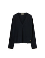 Pull pour femme en pure laine noire, modèle Astrid de la marque MOMONI. Présente une maille teinté en pièce et de délicates bordures en lurex doré aux finitions.