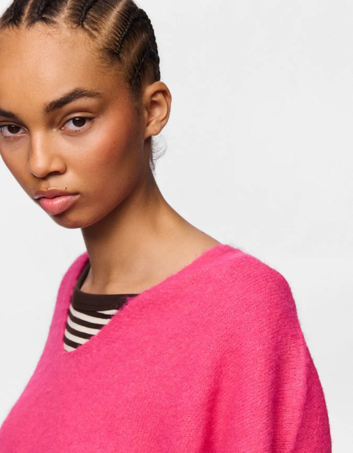 Epaule du Pull sans manches en maille douce rose vif chiné shocking pink avec col en V et coupe ample, modèle Allie de la marque PIECES.