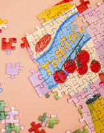 Réalisation du Puzzle 1000 pièces Festin d'été par Jessica Smith pour La Petite Épicerie. Illustration gourmande de grande tablée colorée fabriquée en France, format 68,5x48 cm.