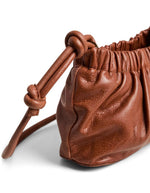 Fermeture du Sac bandoulière compact pour femme en cuir de buffle camel avec détail de nœud sur le devant, modèle Alina Leather Cross Body de PIECES. Fermeture zippée et bandoulière réglable.