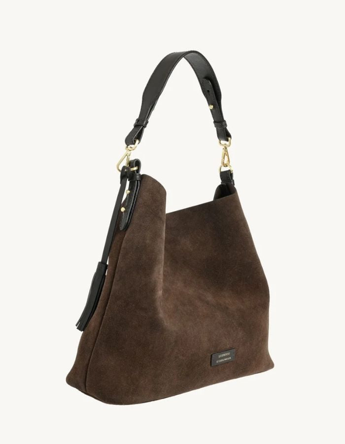 Profil du Sac hobo pour femme en cuir velours marron chocolat avec pompon assorti et porté épaule, modèle Sharon de la marque Loxwood.