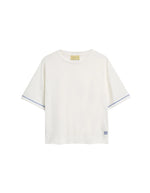 T-shirt oversize à manches courtes pour femme en jersey de coton blanc lurex, modèle Iora de la marque MOMONI. Présente une encolure ronde et de petites fentes latérales.