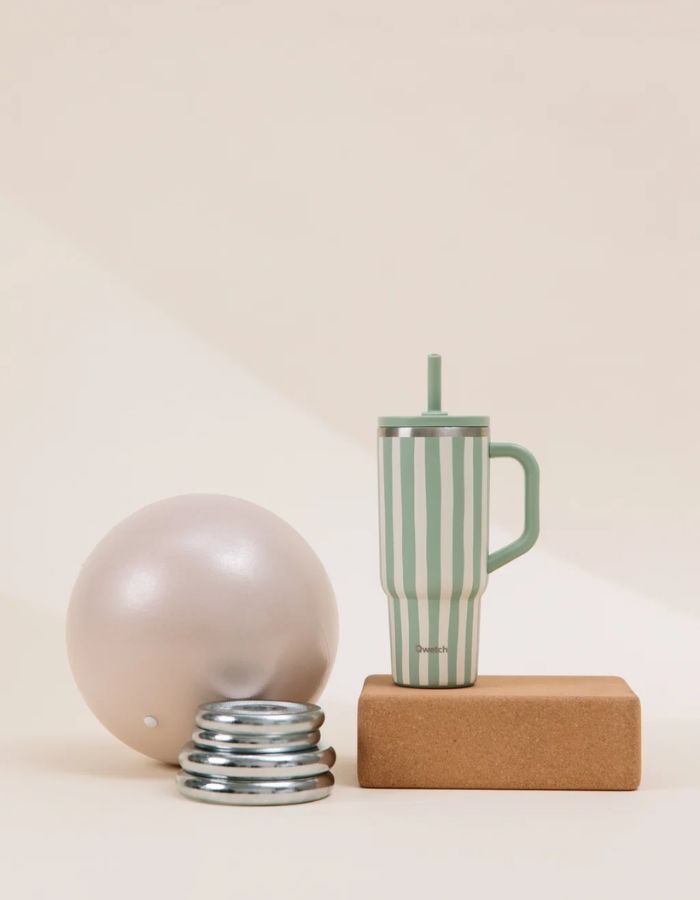 Photo d'ambiance avec le Grand mug isotherme 900ml couleur vert tilleul pastel avec poignée, paille en inox et embout silicone, modèle Travel Cup de la marque QWETCH.
