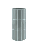 Vase cylindrique en céramique bleu ciel effet carrelage en relief, marque Opjet. Finition émaillée brillante, hauteur de 23 cm et diamètre de 10,5 cm.