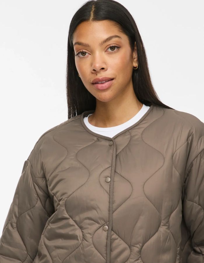 Col de la Veste matelassée courte pour femme beige taupe falcon avec col en V, poches plaquées et fermeture pressionnée, modèle Dune Light de la marque VILA
