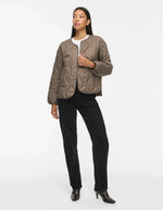 Silhouette avec la Veste matelassée courte pour femme beige taupe falcon avec col en V, poches plaquées et fermeture pressionnée, modèle Dune Light de la marque VILA