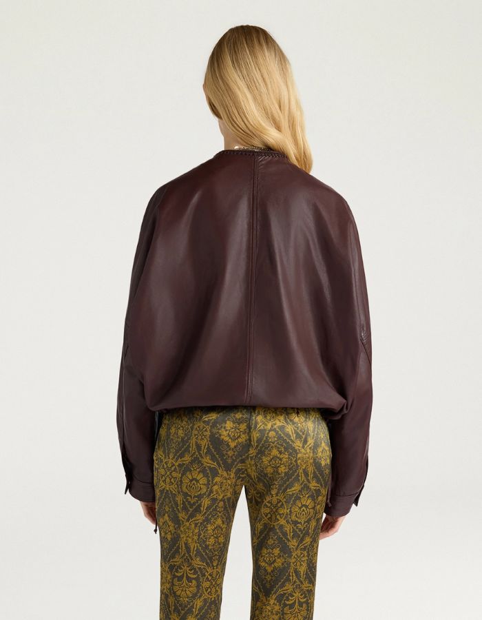 Dos de la Veste bomber courte pour femme en cuir d'agneau marron, modèle Kaldor de la marque MOMONI. Présente une coupe carrée avec cordon de serrage au bas et des boutons-pression en laiton vieilli.