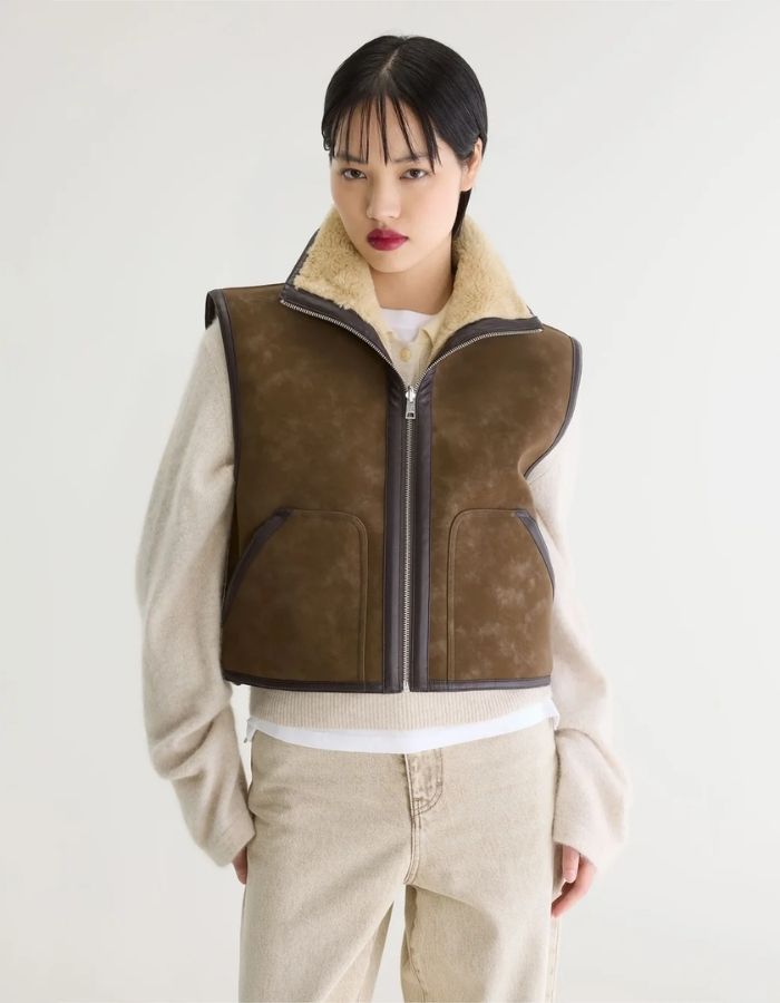 Vue de face de la Veste courte sans manches réversible pour femme en sherpa beige et nubuck marron avec col montant et détails de coutures façon cuir, modèle Jonson de la marque Bellerose.