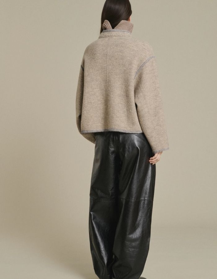 Dos de la Veste courte autrichienne pour femme en laine bouillie beige et grise avec col montant, finitions gansées par une tresse et volume ample, modèle Olympe de la marque Soeur.