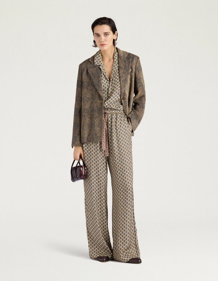 Silhouette avec la Veste de tailleur évasée pour femme en velours côtelé imprimé dentelle, modèle Lilja de la marque MOMONI. Présente une fermeture à un bouton, des fentes latérales et un revers en miroir.