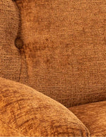 Détail du Fauteuil pivotant Loveuse de couleur orange brûlé avec une large assise moelleuse. Base ronde stable en métal noir, design d'inspiration rétro idéal pour un salon ou une chambre moderne