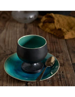 Assiette à dessert Riviera Costa Nova en grès fin turquoise craquelé avec bol noir et cuillère.