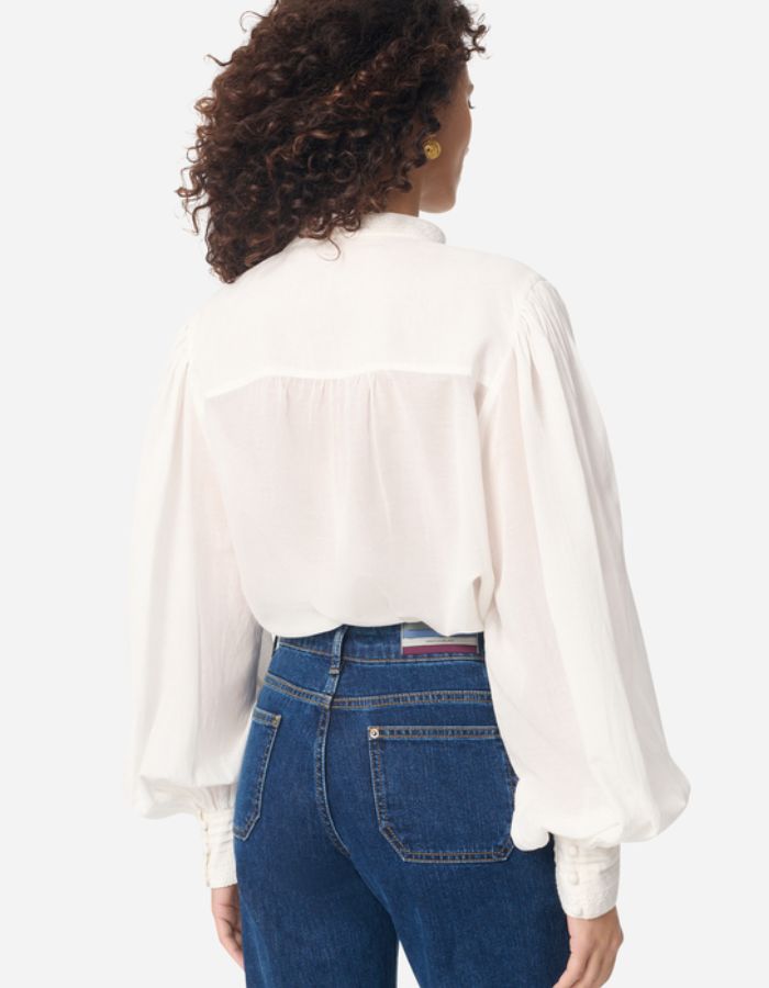 Blouse blanche Gania en voile de coton avec col officier, manches bouffantes et empiècements plissés.
