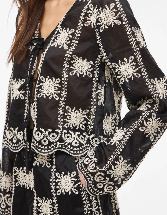 Manche de la Blouse noire à manches longues Nala par Rouge Edit en coloris Meteorite Embroidery. Col en V avec broderies délicates et liens à nouer sur le devant. Tissu fluide et élégant en lyocell et polyester