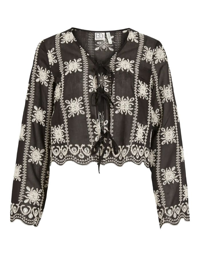 Blouse noire à manches longues Nala par Rouge Edit en coloris Meteorite Embroidery. Col en V avec broderies délicates et liens à nouer sur le devant. Tissu fluide et élégant en lyocell et polyester