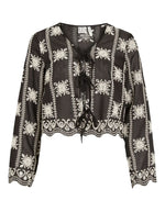Blouse noire à manches longues Nala par Rouge Edit en coloris Meteorite Embroidery. Col en V avec broderies délicates et liens à nouer sur le devant. Tissu fluide et élégant en lyocell et polyester