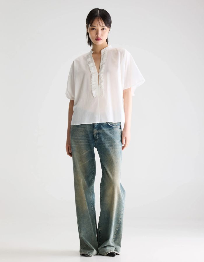 Mannequin portant la blouse Dahlia Blanche Bellerose en coton léger, coupe oversized, col mandarin et volants.