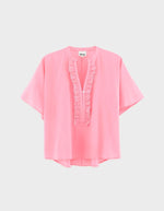 Blouse Dahlia Geranium Bellerose rose vif, coupe oversized, col mandarin, patte de boutonnage à volants, manches dolman courtes.