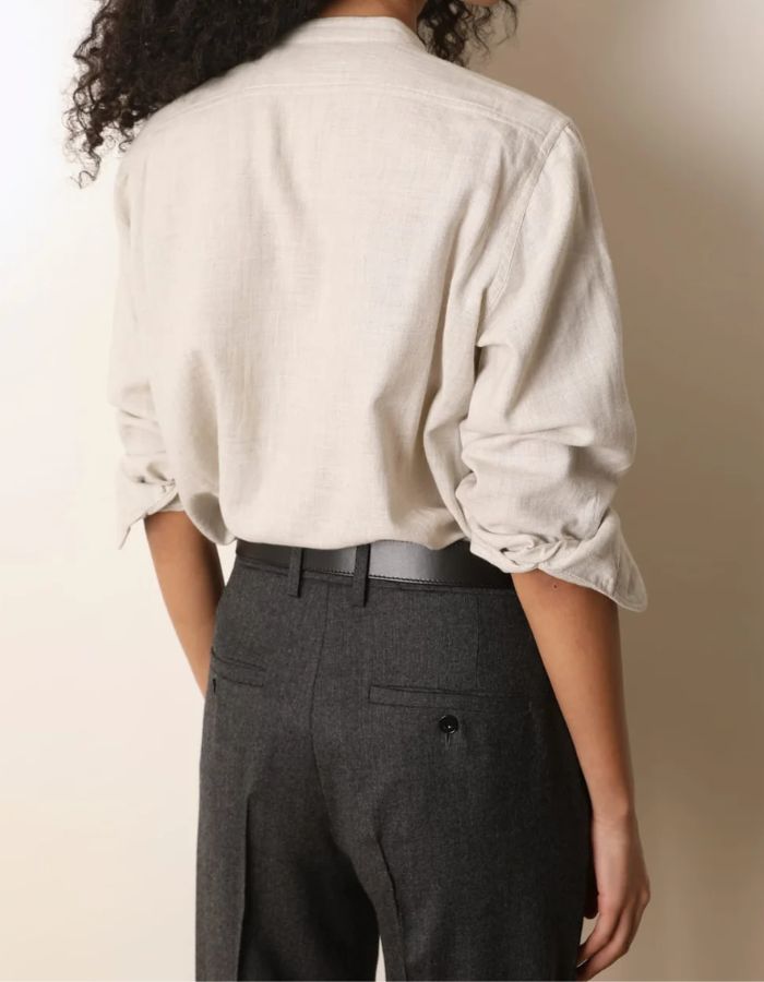Dos e la Blouse fluide pour femme en coton beige off white, modèle Carita de la marque Laurence Bras. Présente un col officier, une fermeture boutonnée sous volant et des manches longues froncées.