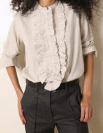 Col de la Blouse fluide pour femme en coton beige off white, modèle Carita de la marque Laurence Bras. Présente un col officier, une fermeture boutonnée sous volant et des manches longues froncées.